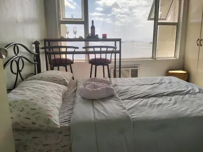 a bedroom with a bed and a table with chairs at Chic Haven in Manila