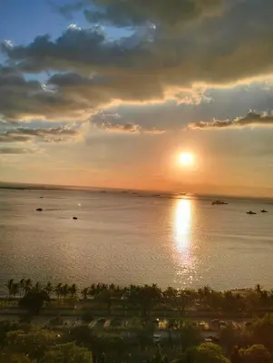 a sunset over a body of water with boats at Chic Haven in Manila