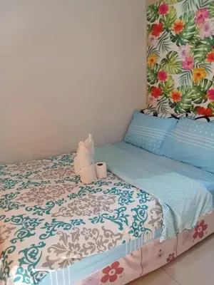 a bedroom with a bed with blue and white sheets at Sea Residence Finest By Douie in Manila