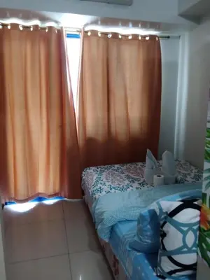 a bedroom with a bed with orange curtains at Sea Residence Finest By Douie in Manila