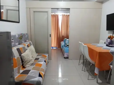 a living room with a couch and a table at Sea Residence Finest By Douie in Manila