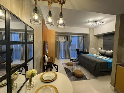 a bedroom with a bed and a living room at Industrial Chic Studio in McKinley Hill Walk to Venice Mall in Manila