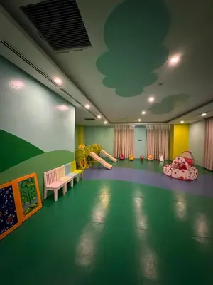 a room with a play area with a slide and a playground at Cozy Viceroy 1BR, Walk to Venice Mall in Manila