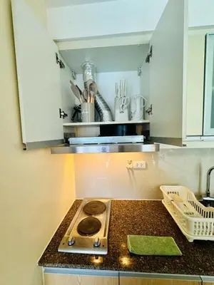 a kitchen with a stove and a counter top at Cozy Viceroy 1BR, Walk to Venice Mall in Manila