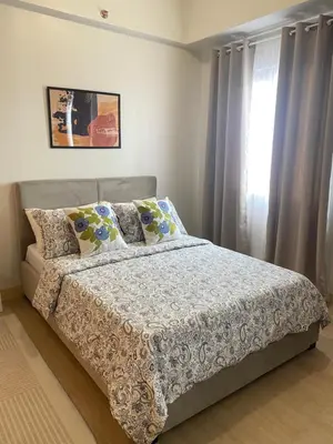 a bedroom with a bed and a window with curtains at Condo unit near SM City Sta Rosa unit 3 in Santa Rosa