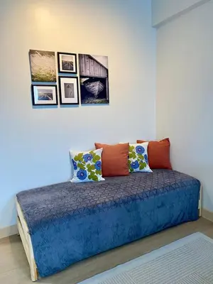 a bed in a room with pictures on the wall at Condo unit near SM City Sta Rosa unit 3 in Santa Rosa