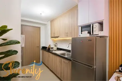 a kitchen with a stainless steel refrigerator and a microwave at Shorenity MOA Staycation in Manila