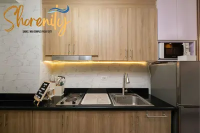 a kitchen with a sink and a refrigerator at Shorenity MOA Staycation in Manila