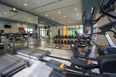 a gym with several tread machines in a room at The Serene Casa - EMANUELE TOWER in Manila
