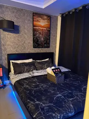 a bedroom with a bed with a black comforter at Celestial Sphere Staycation in Manila