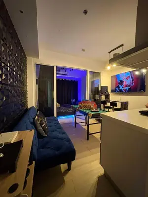 a living room with a couch and a ping pong table at Celestial Sphere Staycation in Manila