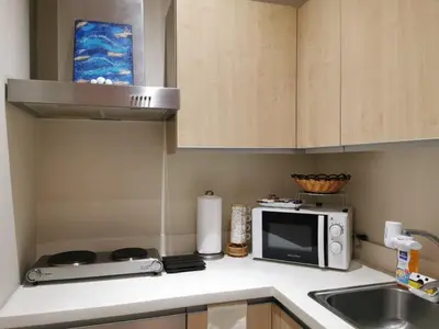 a kitchen with a sink and a microwave at Spacious 1BR APT near Nightlife and Business Center in Makati in Manila