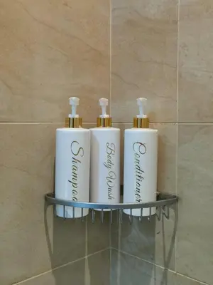 a shelf with three white bottles on it in a bathroom at Spacious 1BR APT near Nightlife and Business Center in Makati in Manila