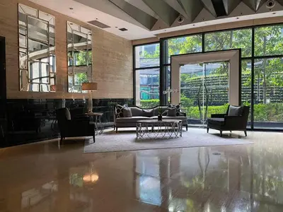 a living room with couches and chairs and windows at Spacious 1BR APT near Nightlife and Business Center in Makati in Manila