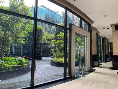 a building with large glass windows and a courtyard with plants at Spacious 1BR APT near Nightlife and Business Center in Makati in Manila