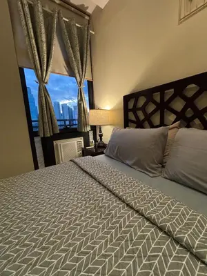 a bedroom with a bed and a large window at Spacious 1BR APT near Nightlife and Business Center in Makati in Manila
