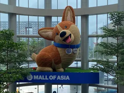 a stuffed animal sitting on a sign in a mall of asia at 2mins to Okada near Airport & MOA with Balcony-8E in Manila
