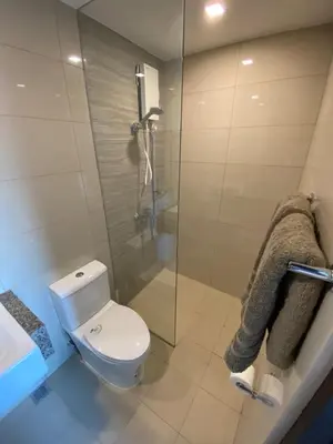 a bathroom with a toilet and a glass shower at 2mins to Okada near Airport & MOA with Balcony-8E in Manila