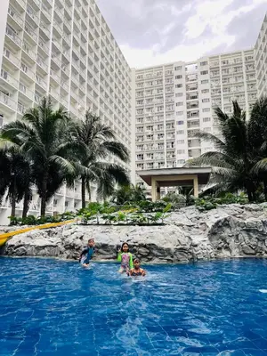 two children playing in a swimming pool at a resort at Shore 1 Condo near MOA - PLS send valid IDs of all guests after booking for guest authorization form purposes in Manila