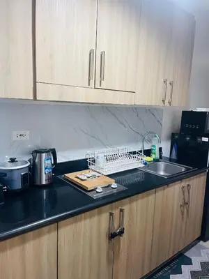 a kitchen with a counter top with a sink and a counter top at Shore 1 Condo near MOA - PLS send valid IDs of all guests after booking for guest authorization form purposes in Manila