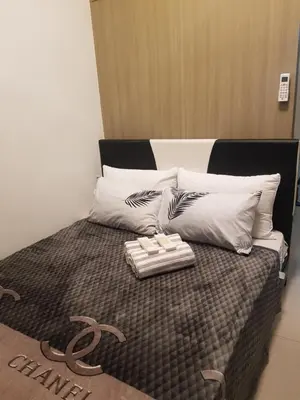 a bed with white pillows and a tray on it at Shore 2 Residences MOA Pasay Naia in Manila
