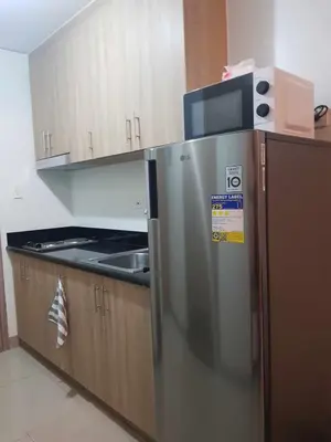 a kitchen with a stainless steel refrigerator with a microwave at Shore 2 Residences MOA Pasay Naia in Manila