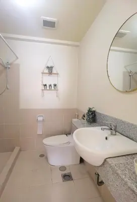 a bathroom with a sink and a toilet and a mirror at Brixton Place in Manila