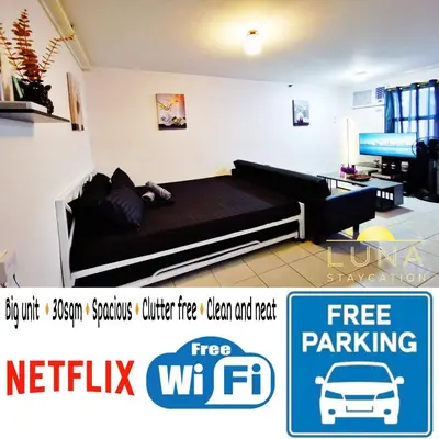 a bedroom with a bed and a couch and a tv at Luna staycation Cozy Condo near Enchanted Kingdom in Santa Rosa
