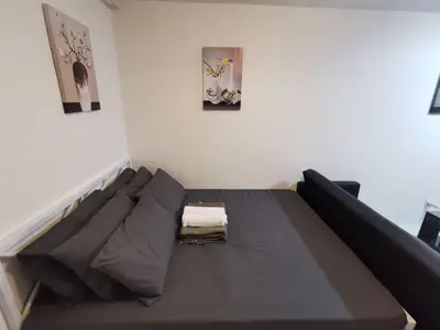 a bed in a room with two pictures on the wall at Luna staycation Cozy Condo near Enchanted Kingdom in Santa Rosa