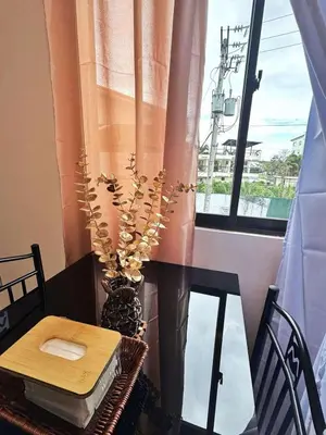 a table and a vase with a plant on a window at Luna staycation Cozy Condo near Enchanted Kingdom in Santa Rosa