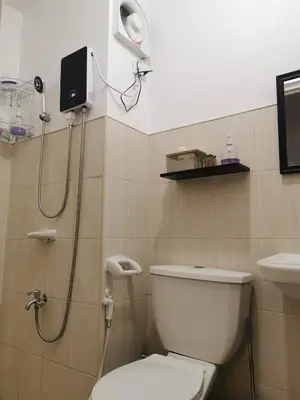 a bathroom with a white toilet and a shower at Luna staycation Cozy Condo near Enchanted Kingdom in Santa Rosa