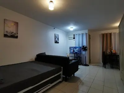 a bedroom with a bed and a couch at Luna staycation Cozy Condo near Enchanted Kingdom in Santa Rosa