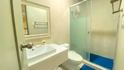 a bathroom with a sink and a toilet and a mirror at Nazville vacation home in Pasig