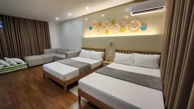 a hotel room with two beds and a couch at Nazville vacation home in Pasig