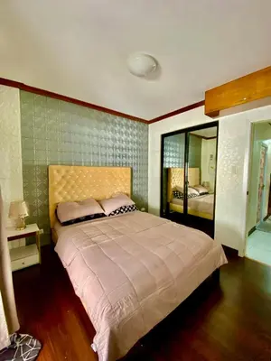 a bedroom with a large bed and a mirror at Dym cozy condo pad in Manila