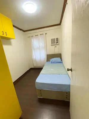 a small bed in a small room with a door at Dym cozy condo pad in Manila