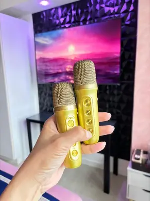 a person holding two microphones in front of a television at Azure Urban Resort Residences - Staycationary Miami 1710 in Manila