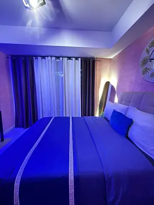 a bedroom with a large bed with a blue light at Azure Urban Resort Residences - Staycationary Miami 1710 in Manila