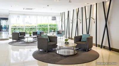 a lobby with chairs and tables in a building at Suite Escapade in Manila