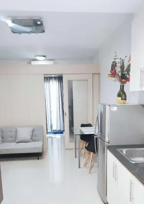 a kitchen and living room with a couch and a table at Suite Escapade in Manila
