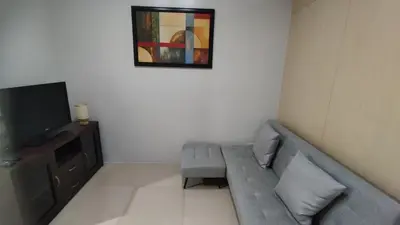 a living room with a couch and a tv at Suite Escapade in Manila