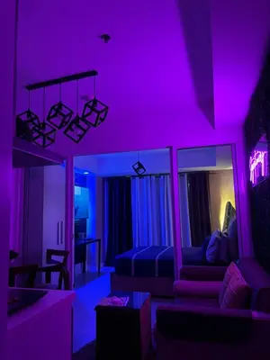 a living room with purple lighting and a couch at Azure Urban Resort Residences by Staycationary 17th floor Miami in Manila