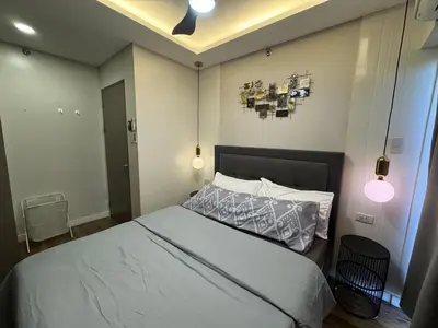 a bedroom with a bed and two lights on the ceiling at Stylish & Spacious Place Near BGC Fast Wi-Fi in Manila