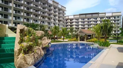 a swimming pool in front of a large building at Stylish & Spacious Place Near BGC Fast Wi-Fi in Manila
