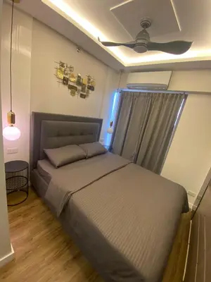 a bedroom with a bed and a ceiling fan at Stylish & Spacious Place Near BGC Fast Wi-Fi in Manila