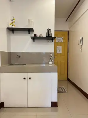 a kitchen with white cabinets and a yellow door at BGC Suites Uptown in Makati