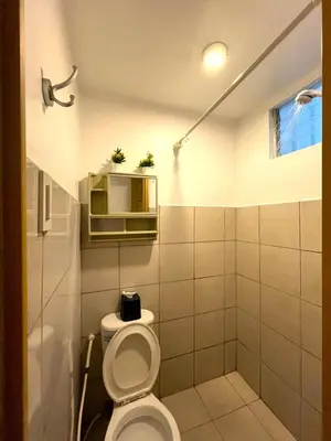 a bathroom with a toilet in a room at BGC Suites Uptown in Makati