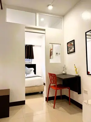 a bedroom with a bed and a desk with a chair at BGC Suites Uptown in Makati
