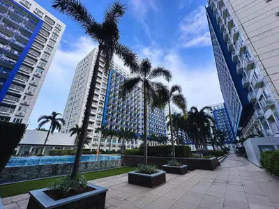 a courtyard with palm trees in a city with tall buildings at MSR Condo Vacation Rental in Manila