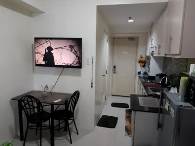 a kitchen with a table and chairs in a room at Arcilla stay cation in Manila